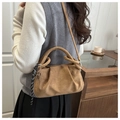 Brown ruched handbag detail with heart pendant and woven strap in a lifestyle setting - Brown No Pendant