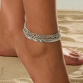 Bracelet de cheville argenté multicouche avec chaîne serpent porté sur la plage - Chevillère Multicouche en Os de Serpent Argentée (1230)