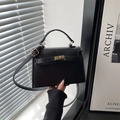 Vintage black lychee pattern tote bag with gold hardware and top handle shown by model - Black