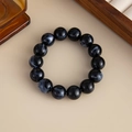 Makroaufnahme eines marmorierten Harzperlenarmbands mit tiefblauen Strukturen und Glanz - Armband - Schwarz