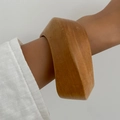 Wide geometric wooden bangle with natural grain finish on female model wrist - Brownish Yellow (0118)