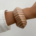Ethnic geometric wooden bangle with striped pattern and faceted edges on a model's wrist - Light Brown Black Mix (0118)
