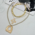 Detailed set of gold-tone necklaces with pearl cross and geometric charms on grey surface - Triple Layer Cross Pearl Style (06328)