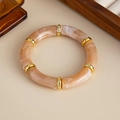 Vista detallada de pulsera de resina ámbar con anillos metálicos dorados pulidos - Estilo de Mármol de Té con Leche (03005)