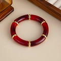 Detaillierte Draufsicht auf Retro-Armreif aus rotem Acryl mit eleganten Goldmetallringen - Bambus-Segment Armreif (3005) / Marmor Weinrot