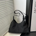 Minimalist black suede hobo shoulder bag featuring central stitching and adjustable straps - Black