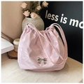 Détail du sac cabas rose clair avec nœud en métal argenté et texture plissée élégante - Violet
