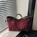 Borsa tote rosa con stampa leopardata e rose posizionata su un davanzale bianco - Rosso