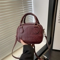Borsa a tracolla rotonda bordeaux minimalista con logo a rilievo e dettagli dorati - Rosso