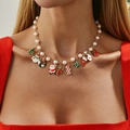 Festive gold necklace with Christmas charms and pearls shown on a female model - Gold (7428)