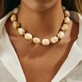 Ethnic necklace with irregular cream resin beads and gold accents worn by a model - White (0077)