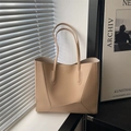 Minimalist beige leather tote bag with elegant geometric stitching on a sunny window sill - Khaki