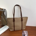 Minimalist bicolor tote bag with khaki body and brown handles on a wooden table - Khaki