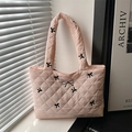 Pink quilted tote bag with black bow embroidery and silver charm in a lifestyle setting - Pink