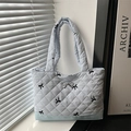 Light blue quilted tote bag with black bow embroidery and silver pendant detail - Blue