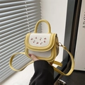 Detail of a mini square crossbody bag with yellow and white cherry print and gold hardware - Yellow