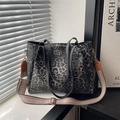 Large leopard print tote bag with black handles and woven strap in sunlight - Black