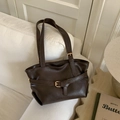 Vintage deep brown faux leather tote bag with buckle detail on a white sofa - Brown