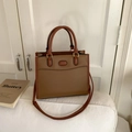 Bolso tote retro marrón con asas cilíndricas y detalles dorados sobre fondo blanco - Tostado
