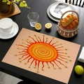 Linen placemat with vibrant orange sun pattern on a black wooden dining table - Spiral Texture Sun