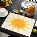 Linen placemat featuring a bright orange sun print on a beige woven texture background - Cream Woven Sun