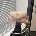 Rosa karierte Umhängetasche mit 3D-Schleife und süßem Teddy-Anhänger am Fensterhintergrund - Kirschblütenrosa