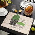 Linen placemat with cactus design and text on dark wood table with dining props - Home Is Where My Plants Are