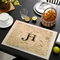 Tovaglietta in lino con lettera H e scritte vintage su tavolo in legno nero - Lettera H
