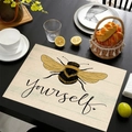 Linen placemat with hand-drawn bee pattern and 'Yourself' text on dark wood table - Bee Stationery Yourself