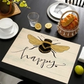 Linen placemat with bee print and happy text on a dark wood dinner table - Bee Stationery Happy