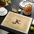 Tovaglietta in lino con lettera K dell'alfabeto vintage su tavolo in legno rustico - Lettera K