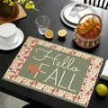 Detalle del mantel individual de lino Hello Fall con hojas de otoño en mesa negra - Estilo Hello Fall Verde