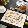 Linen placemat with 'BE thankful' pumpkin and floral print on a dark dining table - Floral Pumpkin Style