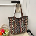 Ethno-Tote-Bag mit bunten Wellenmustern und braunen Ledergriffen an einer weißen Wand - Khaki