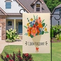 Détail du drapeau de jardin tulipes suspendu à un mât métallique dans une cour verte - Bouquet Enveloppé de Papier Kraft (Anniversaire Russe)