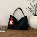 Large black suede tote bag with a red apple charm on a minimalist wooden surface - With Pendant / Black