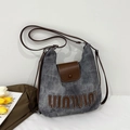 Borsa tote in tela grigia e pelle marrone esposta con tulipani in un ambiente sobrio - Marrone Scuro