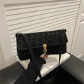 Chic black leopard print shoulder bag with gold metal buckle on a minimalist setting - Black
