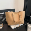Minimalist large capacity camel tote bag with gold lettering shown in a stylish setting - Khaki