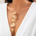 Goldene Ginkgoblatt Quasten-Halskette getragen von einem Modell in weißem Oberteil - Mehrlagige Ginkgoblatt-Anhänger-Halskette / Gold