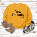 Detail of yellow sweatshirt with 'Yes, I'm cold' print on wooden background - S / Yellow