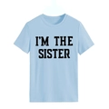 Gros plan sur l'imprimé noir I'M THE SISTER sur un t-shirt femme bleu clair à col rond - Bleu Clair (Police Noire)