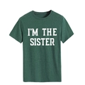 Gros plan du texte blanc 'I'M THE SISTER' imprimé sur un T-shirt en coton vert foncé - Vert Rétro (Police Blanche)