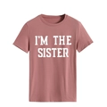 Détail du col rond et de l'imprimé I'M THE SISTER sur le t-shirt en coton rose - Or Rose (Police Blanche)