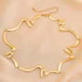 Détail du collier doré ondulé sur soie, montrant le fermoir et la finition polie chic - Style Or Vague Torsadée (06375)