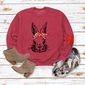 Gros plan d'un sweat-shirt rouge vin avec motif lapin sur un fond de plancher en bois - Rouge Imprimé Lapin (Texte Noir)