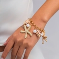 Bohemian gold chain bracelet with starfish, pearls, and natural shells on woman's wrist - Gold Bracelet (E2787)