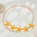 Detailed view of gold chain body belt with yellow starfish charms and pearl accents - Gold + Yellow
