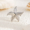 Macro view of silver starfish ear cuff with beaded texture on a white beach background - Silver Textured Sea Star Style (03554)