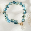 Close-up of shell necklace with blue iridescent pieces, baroque pearl and golden OT buckle - Gold + Blue Style (06639)